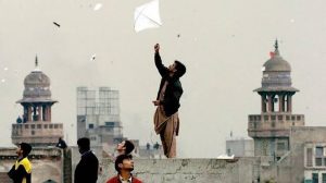 پولیس اہلکار کٹے ہوئے دھاگے اور ضبط شدہ پتنگیں دکھاتے ہوئے