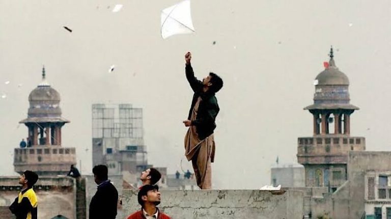 پولیس اہلکار کٹے ہوئے دھاگے اور ضبط شدہ پتنگیں دکھاتے ہوئے