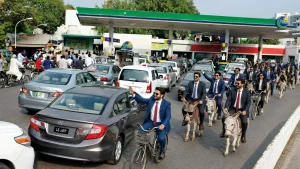 پٹرول پمپ پر قیمتوں کا بورڈ اور گاڑی میں ایندھن ڈالتا شخص