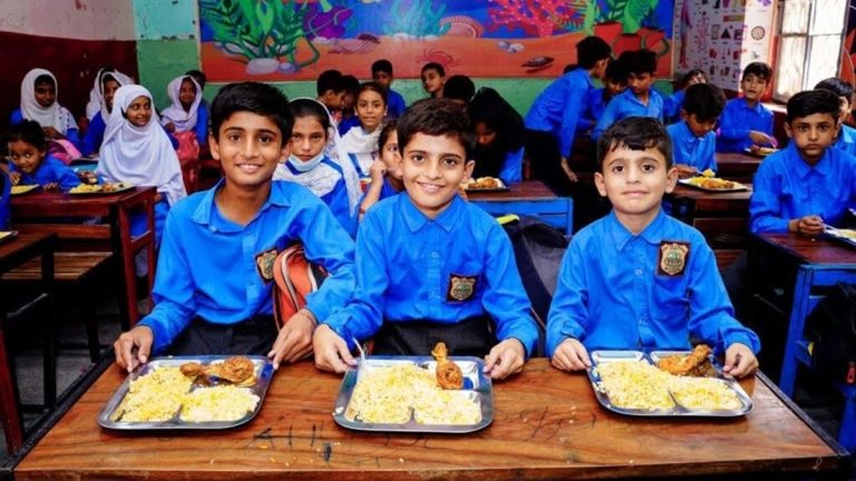 اسکول کے بچے دودھ اور بسکٹ وصول کرتے ہوئے