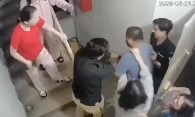 ڈی ایچ اے فیز 6 اپارٹمنٹ کی سیڑھیوں پر مبینہ جھڑپ کا سی سی ٹی وی فریم جس میں افراد جھگڑتے اور پولیس یونیفارم کے شکوک دکھائی دے رہے ہیں