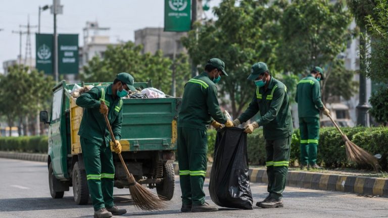 محکمہ ایکسائز اینڈ ٹیکسیشن کے اہلکار بل تقسیم کرتے ہوئے