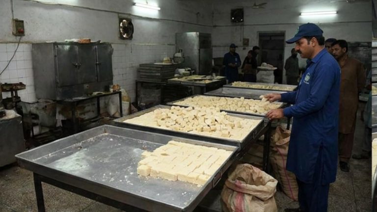 پنجاب فوڈ اتھارٹی کے اہلکار کھاریان میں ضبط شدہ بارفی کا معائنہ کر رہے ہیں
