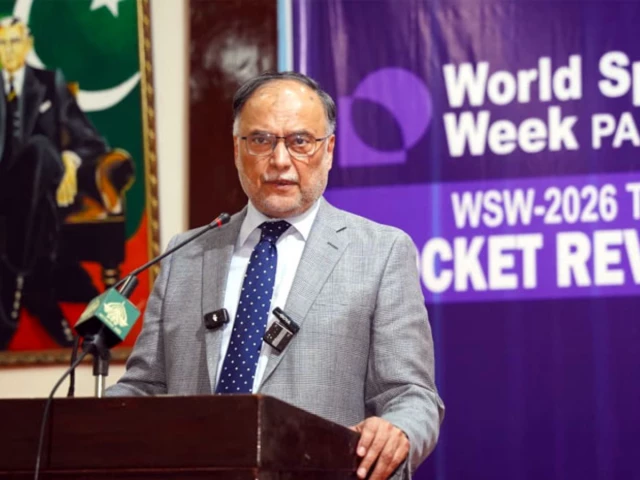 احسان اقبال عالمی خلائی ہفتۂ 2026 کے اختتامی سیشن میں مائیکروفون کے ساتھ کھڑے ہیں